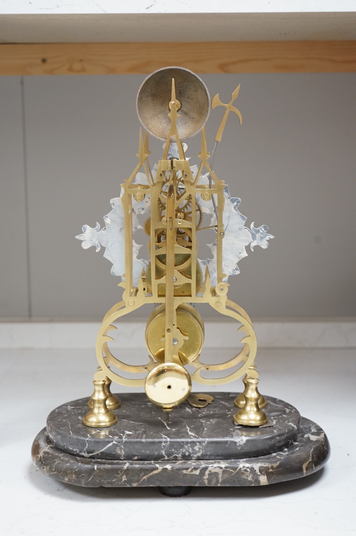 A large skeleton clock under dome, on grey marble base. 44cm high